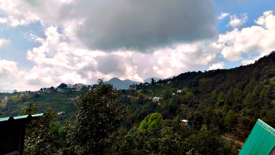 Forested Kumaon hills and clouds seen from The Rare One’s Resort near Mukteshwar