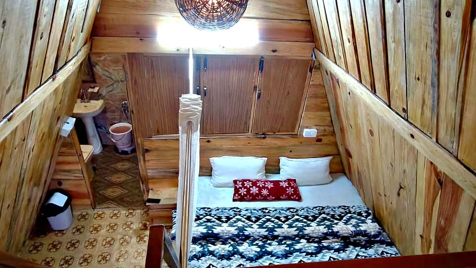A-frame cottage bedroom with a double bed at The Rare One’s Resort, Mukteshwar