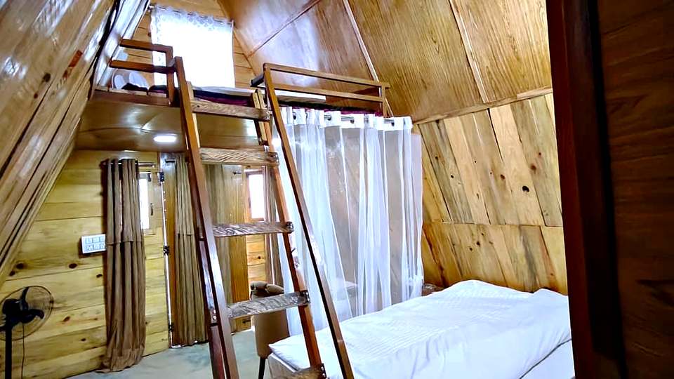 A-frame cottage with a loft and ladder at The Rare One’s Resort, Mukteshwar