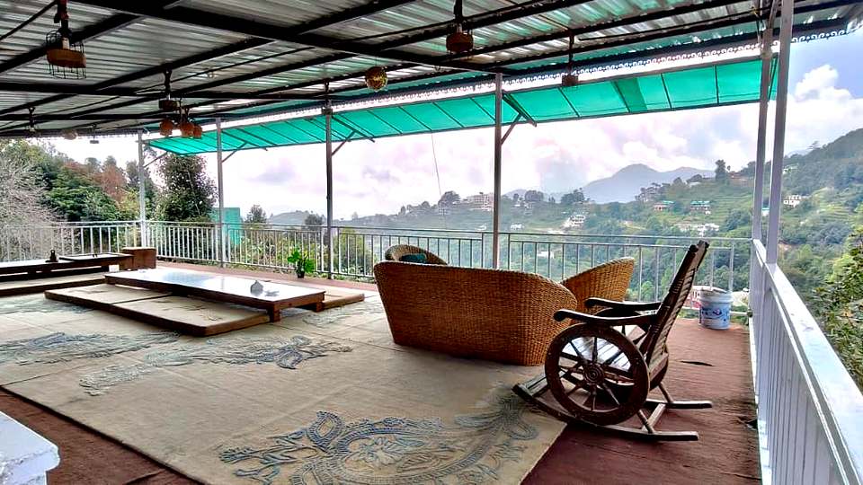 Floor seating and rocking chair at the café, The Rare One’s Resort, Mukteshwar